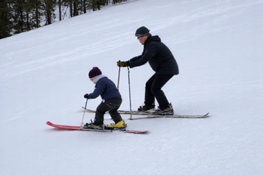 A beginner skier learning to snowplow on a gentle, wide slope with an instructor