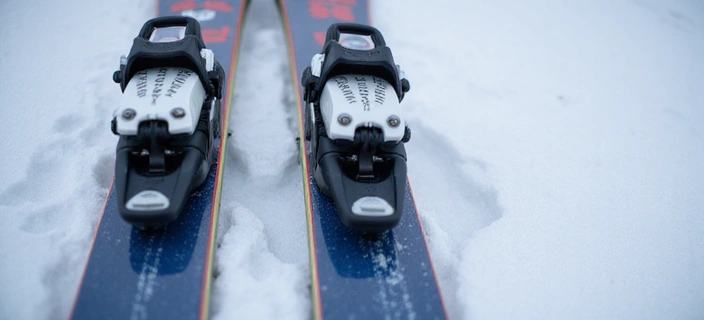 Close-up of modern alpine skis with bindings on a snowy surface
